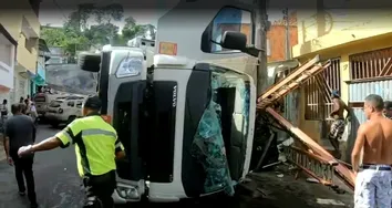 CAMINHÃO TOMBA E ESMAGA CARRO NO LOBATO; CARGA FOI SAQUEADA